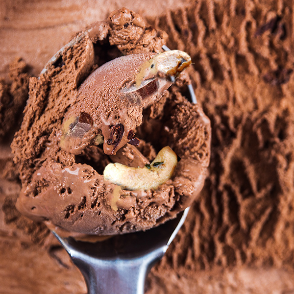 Full ice cream scoop in chocolate ice cream tub. Macro texture