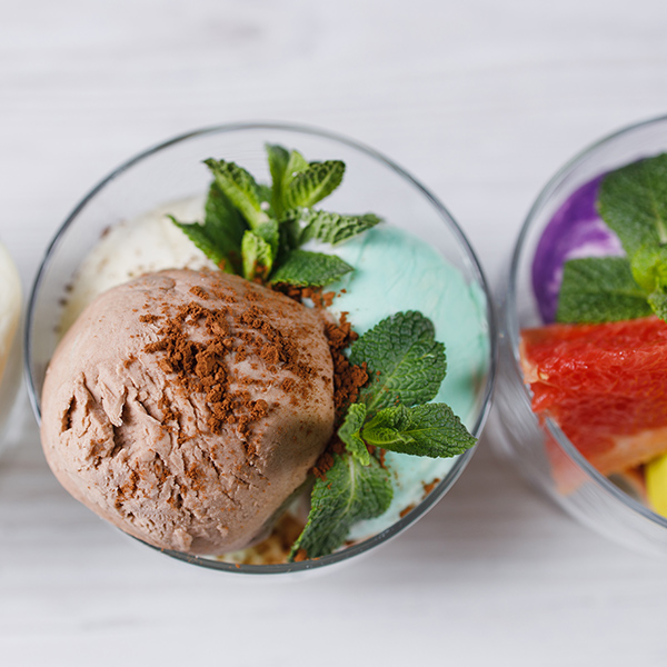 Set of ice cream scoops of different colors and flavors in glass sundae bowls. Summer delicious food, tasty refreshing dessert
